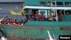 Some migrants despair after the Thai navy tows their boat away from Thailand, in waters near Koh Lipe island, May 16, 2015.