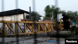 FILE - Palestinian laborers working in Israel make their way to their workplaces through the main Israeli terminal near the West Bank town of Qalqilya.