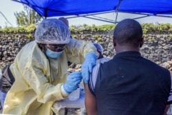 FILE - A man receives a vaccine against Ebola from a nurse outside the Afia Himbi Health Center in Goma, July 15, 2019.