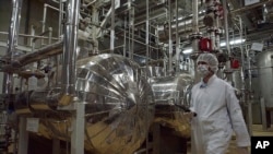 FILE - An Iranian security official in protective clothing walks through part of the Uranium Conversion Facility just outside the Iranian city of Isfahan in this undated photo.