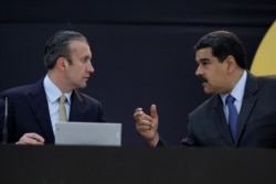 Venezuela's President Nicolas Maduro, right, speaks with Tareck El Aissami as they attend the event launching the new Venezuelan cryptocurrency "petro" in Caracas, Feb. 20, 2018.