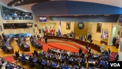 Los nuevos legisladores alzan la mano para destituir al Fiscal General de El Salvador, y a los magistrados propietarios y suplentes de la Corte Suprema de Justicia durante su primera sesión. Mayo 1, 2021.