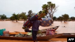 Un homme transporte ses affaires dans une pirogue le 5 septembre 2013. Il quitte un quartier de Niamey où les inondations ont fait 26 morts et 75 347 sinistrés. Elles ont aussi détruit 13 000 ha de terres agricoles et causé plusieurs dégâts. PHOTO AFP / BOUREIMA HAMA 
