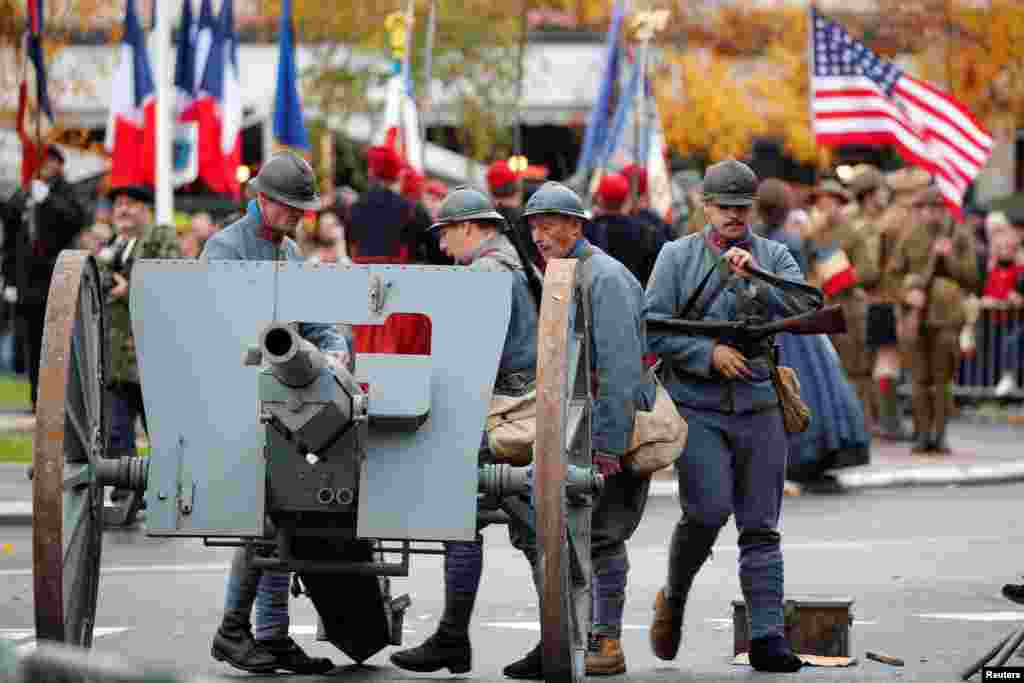 History enthusiasts dressed as French soldiers prepare to fire a cannon during a commemoration ceremony for Armistice Day, in Epernay, France, Nov. 11, 2018.