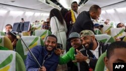 Passengers pose for a selfie picture inside an Ethiopian Airlines flight which departed from the Bole International Airport in Addis Ababa, Ethiopia, to Eritrea's capital Asmara on July 18, 2018. 