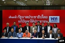 Puea Thai Party leader Cholnan Srikaew (centre R) speaks next to Move Forward Party secretary general Chaitawat Tulathon (centre L) during a press conference alongside members of the eight-party coalition after a meeting to discuss plans ahead of next wee