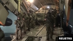 Russian troops disembark from a military aircraft, as part of a mission of the Collective Security Treaty Organization amid mass protests in Almaty and other Kazakh cities, at an airfield in Kazakhstan. Photo released by Russia's Defense Ministry Jan. 8, 2022.