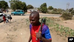 Tinashe Mapuranga works outside his home near Harare, Zimbabwe, on Aug, 25, 2021. Amid the lockdowns from the coronavirus pandemic, the 24-year-old was one of the first to be laid off from his job as an intern at a leading bank.