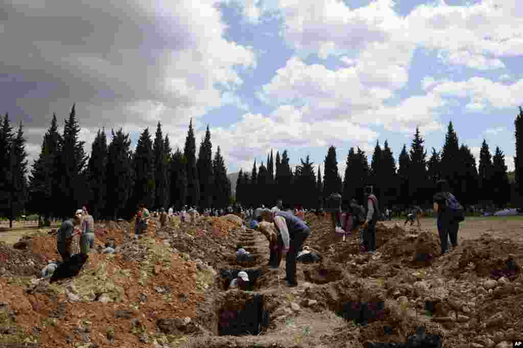 People prepare graves for the coal mine disaster victims in Soma, May 15, 2014.