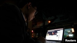 FILE - A Vietnamese internet activist posts a status on Facebook at a cafe in Hanoi, Nov. 27, 2013.