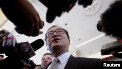 FILE - Sam Rainsy, leader of the Cambodia National Rescue Party (CNRP), speaks to media after a meeting at the National Assembly in Phnom Penh.