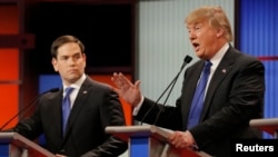 Republican U.S. presidential candidate Marco Rubio listens as rival candidate Donald Trump speaks at the U.S. Republican presidential candidates debate in Detroit, Michigan, March 3, 2016.