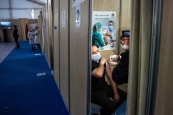 FILE - A Moroccan nurse administers the AstraZeneca COVID-19 vaccine to a health worker, on the first day of vaccination campaign, in Rabat, Jan. 29, 2021.