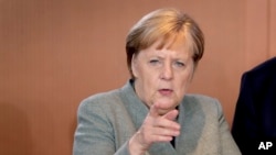 FILE - German Chancellor Angela Merkel arrives for the weekly cabinet meeting at the Chancellery in Berlin, Germany, Dec. 18, 2019. 