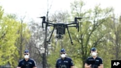 Police officers prepare a drone to find residents who fail to comply with the stay-at-home order implemented due to the coronavirus pandemic in Szolnok, Hungary, April 13, 2020.