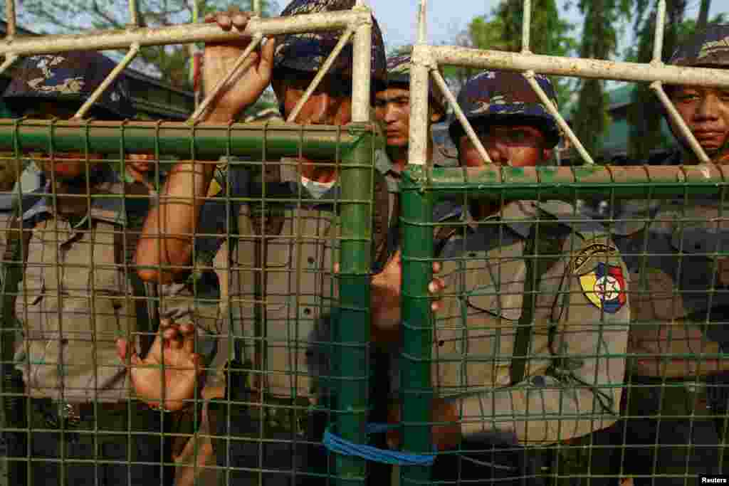 Police stand guard in front of a courthouse after the arrival of student protesters, in Letpadan, March 11, 2015.