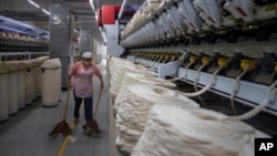 A worker sweeps loose cotton near a production line at the Wenzhou Tiancheng Textile Company, one of China's largest cotton recycling plants in Wenzhou in eastern China's Zhejiang province on March 20, 2024.
