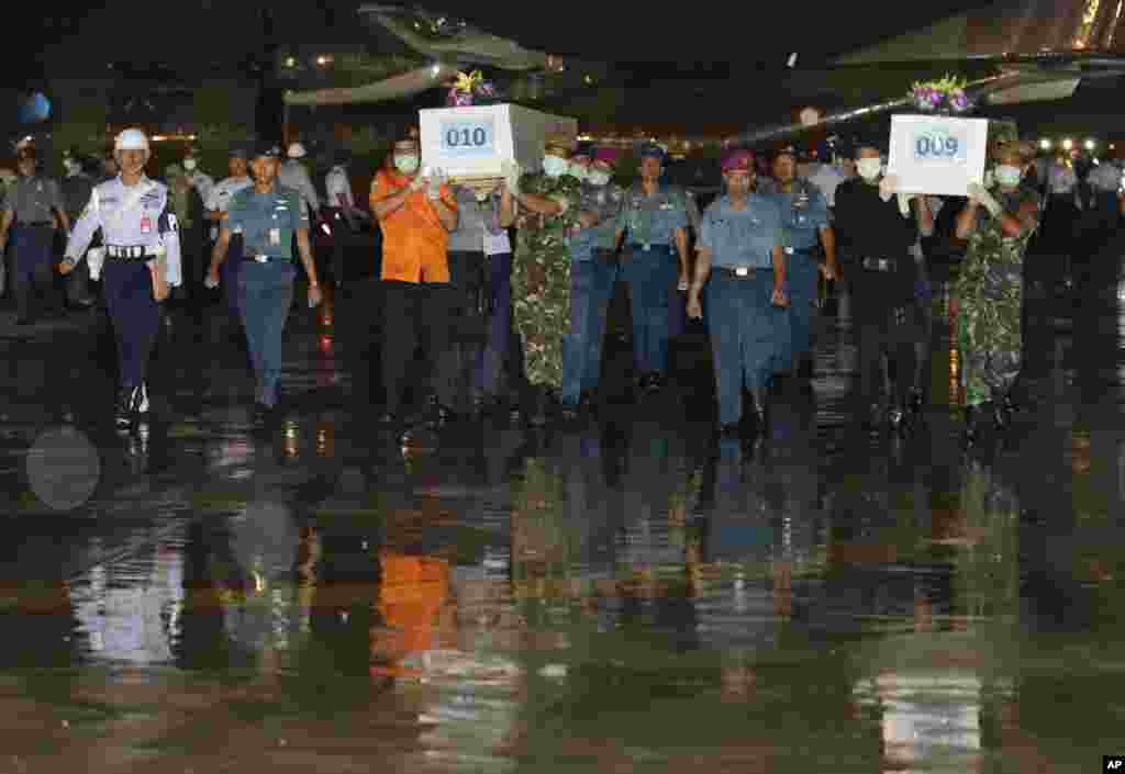 Indonesian military personnel carry coffins containing the bodies of victims of AirAsia Flight 8501 upon arrival at Juanda Naval Airbase in Surabaya, East Java, Indonesia, Jan. 2, 2015.