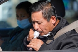 A man takes a COVID-19 saliva test at the University of Utah Health Wellness Bus mobile testing site, in West Valley City, Utah, Oct. 26, 2020.
