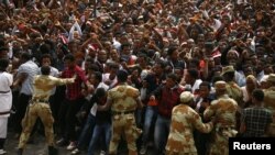 FILE - Demonstrators chant slogans while flashing the Oromo protest gesture during Irreecha, the thanksgiving festival of the Oromo people, in Bishoftu town, Oromia region, Ethiopia, Oct. 2, 2016.