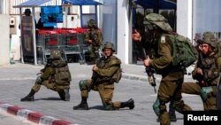 Israeli soldiers work to secure residential areas following a mass-infiltration by Hamas gunmen from the Gaza Strip, in Sderot