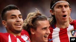 Atletico de Madrid Antoine Griezmann, au centre, célèbre avec ses coéquipiers Filipe Luis, à droite, et Correa, à gauche, après avoir marqué un but lors d'un match de football de la Liga espagnole entre le Real Madrid et l'Atlético de Madrid au stade Sant