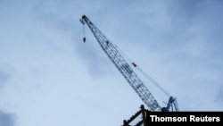 A crane is seen at a construction site during sunset hour in Taipei, Taiwan, on July 8, 2020.
