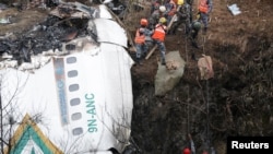 FILE - A rescue team works to recover the body of a victim from the site of the plane crash of a Yeti Airlines operated aircraft, in Pokhara, Nepal Jan. 16, 2023.
