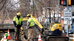 FILE - Construction laborers work in Wheeling, Ill., March 31, 2021. America's infrastructure received an overall grade of C-, according to a 2021 report by the American Society of Civil Engineers.