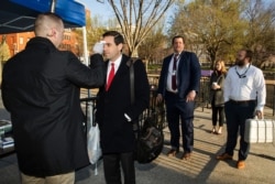 A White House medical staff checks body temperature of journalists and staff before they enter the White House perimeter, March 16, 2020, in Washington.