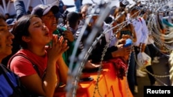 Camila Paz, an 18-year-old Venezuelan migrant takes part in a protest at the Paso del Norte international bridge to request asylum in the United States, seen from Ciudad Juarez, Mexico, March 12, 2023. 