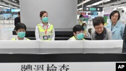 Hong Kong Chief Executive Carrie Lam, second from right, and Secretary for Food and Health, Prof. Sophia Chan, right, reviews the health surveillance by officers of the Port Health Division at West Kowloon Station in Hong Kong, Jan. 3, 2020.