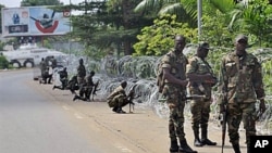 Armed members of the New Forces adopt combat positions near the hotel that houses the rival government declared by Alassane Ouattara in Abidjan, Ivory Coast, on Dec 13, 2010