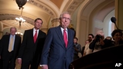 FILE - Senate Majority Leader Mitch McConnell, R-Ky., Sen. James Inhofe, R-Okla., a member of the Senate Armed Services Committee (far-L) and Sen. John Barrasso, R-Wyo., (2nd-L) arrive for a news conference on Capitol Hill in Washington, June 12, 2018.
