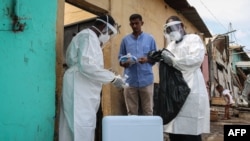FILE - Staff members of the Ministry of Health visit residents to take samples during the first day of mass testing of the COVID-19 coronavirus in Djibouti on May 2, 2020. 