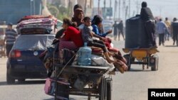 Palestinians travel in an animal-drawn cart as they flee Rafah after Israeli forces launched a ground and air operation in the eastern part of the southern Gaza Strip city on May 9, 2024.