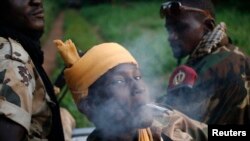 FILE - A Seleka fighter smokes during a patrol, close to the border of the Democratic Republic of Congo June 10, 2014.
