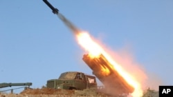 In this undated photo released by the Korean Central News Agency (KCNA) and distributed March 14, 2013, by the Korea News Service, a rocket launcher is fired during a live drill by the Jangjae Islet Defense Detachment and the Mu Islet Hero Defense Detachment.