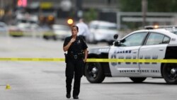 A Dallas police officer guards the scene of last night's shooting as investigators work in downtown Dallas on July 8, 2016. (AP) 