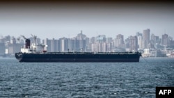 FILE - An oil tanker is seen against the backdrop of the city skyline of Maracaibo, Venezuela, March 15, 2019.