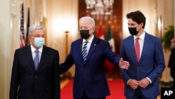 President Joe Biden, center, walks with Mexican President Andrés Manuel López Obrador, left, and Canadian Prime Minister Justin Trudeau, right, to a meeting in the East Room of the White House in Washington, Nov. 18, 2021.