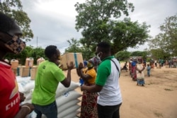 A woman receives food during an United Nations World Food Program's distribution at the "3 de fevereiro escola" school in Matuge district, northern Mozambique, on Feb. 24, 2021