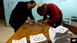Para petugas pemilu menghitung surat suara pada hari terakhir referendum amandemen konstitusi di sebuah tempat pemungutan suara di Kairo, Mesir, 22 April 2019.
