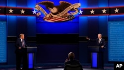 Predsednik Donald Tramp, levo, i predsednički kandidat demokrata i bivši potpredsednik Džo Bajden, desno, govore tokom prve predsedničke debate sa moderatorom Krisom Volisom sa Foks njuza, 29. septembra 2020.