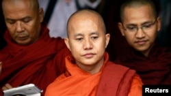 FILE - Buddhist monk Wirathu (C), leader of the 969 movement, greets other monks as he attends a meeting on the National Protection Law at a monastery outside Yangon.