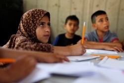 FILE - Children attend an Arabic language lesson given by a Palestinian school girl Fajr Hmaid, 13, as Gaza schools are shut due to the coronavirus disease (COVID-19) restrictions, May 19, 2020.
