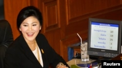 Perdana Menteri Thailand Yingluck Shinawatra tersenyum di tengah proses pemungutan suara untuk mosi tidak percaya di Bangkok (28/11).