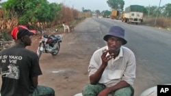 Egyptian Christians watch the funeral of Pope Shenouda, seen in the poster at left, at St. Mark Coptic Orthodox Church in Cairo, March 20, 2012. (AP)

