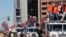 Members of the Denver Broncos wave to adoring fans from atop a fleet of firetrucks during a Super Bowl victory parade in Denver, Feb. 9, 2016.