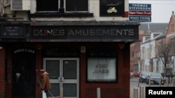 A man walks past a closed bar in the city center ahead of the spring budget announcement amid the coronavirus crisis, in Middlesbrough, Britain, March 3, 2021.